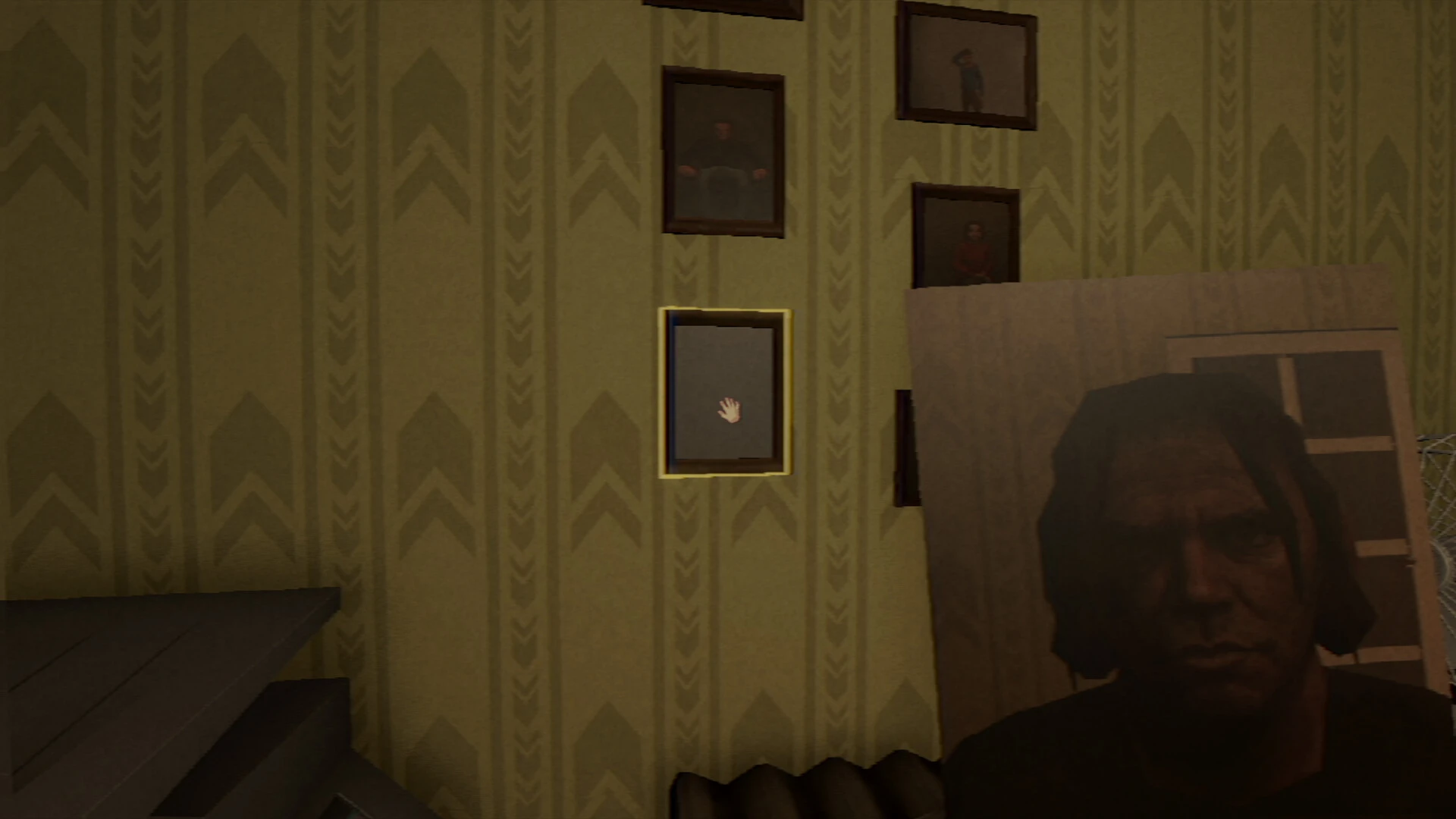 Framed portraits hung on patterned wallpaper, one empty frame waiting